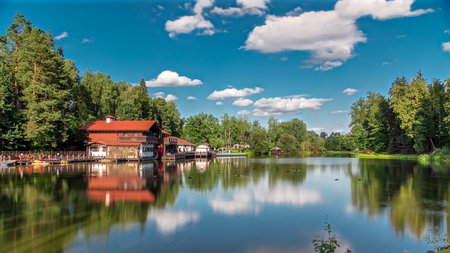 View of the pond, blooming meadow, forest and cottages in village at summer timelapse hyperlapseの写真素材