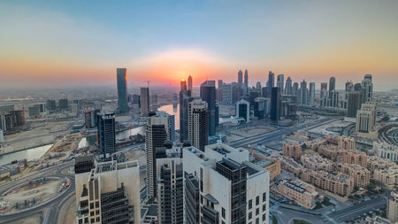 Aerial view of a big modern city with sunset timelapse. Business bay, Dubai, United Arab Emirates.
