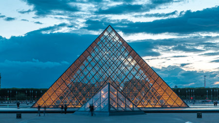 The Louvre museum pyramid after sunset day to night timelapse in Paris, Franceの写真素材