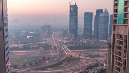 Aerial view of a road intersection in a big city night to day timelapse.の写真素材