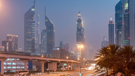 Traffic on intersection and bridge at the Sheikh Zayed Road day to night timelapseの写真素材