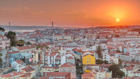 Lisbon at sunset aerial panoramic view of city centre with red roofs at autumn evening timelapse, Portugalの写真素材