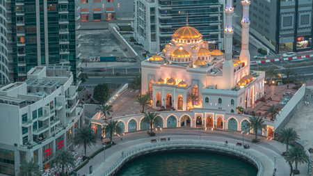 Modern residential architecture of Dubai Marina and Mohammed Bin Ahmed Almulla Mosque aerial day to night timelapseの写真素材