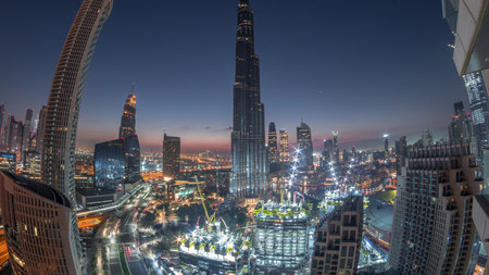 Panoramic skyline view of Dubai downtown before sunrise with mall, fountains and skyscrapers aerial...