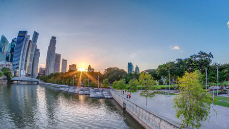 Sunset over Singapore skyscrapers skyline with white Anderson Bridge near esplanade park timelapse.の写真素材