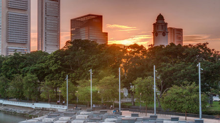 Sunset over Singapore skyscrapers skyline with white Anderson Bridge near esplanade park timelapse.の写真素材