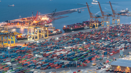 Seaport and loading docks at the port with cranes and multi-colored cargo containers day to night...
