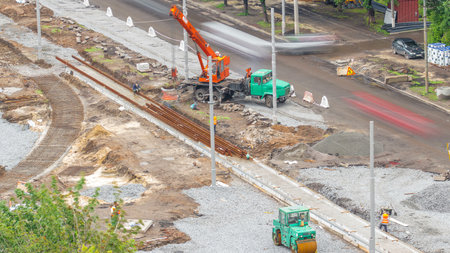 Orange construction telescopic mobile crane unloading tram rails aerial timelapse.