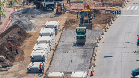 Green vibration roller compactor rolls on a stones at road construction and repairing timelapse