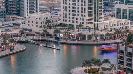 Luxury Dubai Marina canal with passing boats and promenade day to night timelapse, Dubai, United Arab Emiratesの写真素材