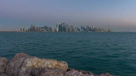 Skyline of Doha night to day transition timelapse in Qatarの写真素材