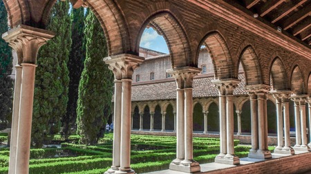 The Basilique de Toulouse central garden square,surrounded by columned passages.Showing the Romanesque architecture.のeditorial素材