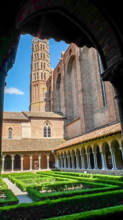 The Romanesque tower looms over the Basilique de Toulouse central garden square,surrounded by columned passages.Showing the Romanesque architecture.のeditorial素材