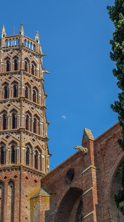 The Romanesque tower looms over the The Romanesque tower of the Basilique Sernin de Toulouse central garden square,surrounded by columned passages.Showing the Romanesque architecture.の写真素材