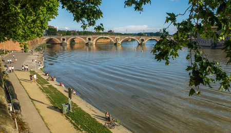Local people and students relax along the western bank of the river running through Toulouse, in the sunlight of late afternoon.のeditorial素材