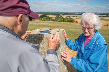 90 year old man takes his wife,who has severe sight loss to Danebury Ring in Wiltshire to get her out in nature and away from the confines of her house bound lifestyle.She has accute macular degeneration.の写真素材