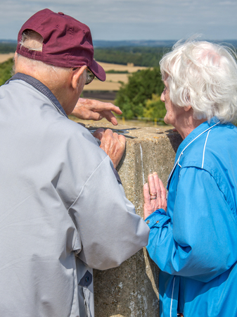 90 year old man takes his wife,who has severe sight loss to Danebury Ring in Wiltshire to get her out in nature and away from the confines of her house bound lifestyle.She has accute macular degeneration.の写真素材