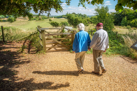 90 year old man takes his wife,who has severe sight loss to Danebury Ring in Wiltshire to get her out in nature and away from the confines of her house bound lifestyle.She has accute macular degeneration.の写真素材