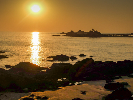 The setting sun and calm seas of this beautiful stretch of coast in southwestern India.の写真素材