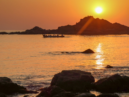 The setting sun and calm seas of this beautiful stretch of coast in southwestern India.の写真素材