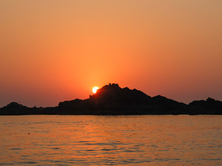 The setting sun and calm seas of this beautiful stretch of coast in southwestern India.の写真素材