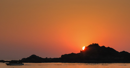 The setting sun and calm seas of this beautiful stretch of coast in southwestern India.の写真素材
