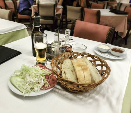 At at a restaurant in Montenegro's capital city.with salad dressing,olive oil,mayonaisse,salt,pepper, ketchup and local beer.の写真素材