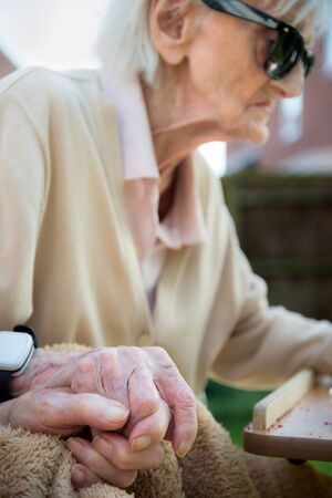 Husband and wife in their 90s still in love and the wife has early stage dementia.Natural and unposed in their back garden during springtime.の写真素材