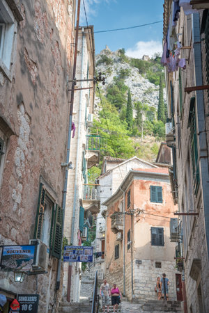 Tourists and locals alike walking along the narrow shady streets of the Old Town during a sunny mid afternoon.のeditorial素材