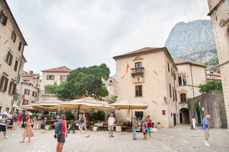 Kotor main square as seen through the archway of the Sea Gate,surrounded by ancient medieval buildings,resaurants and tourist shops.のeditorial素材