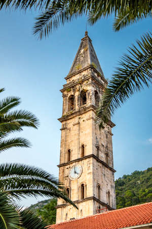 Next to the square at the Bay of Kotor in the late afternoon towards sunset with palm tree in the foreground.の写真素材