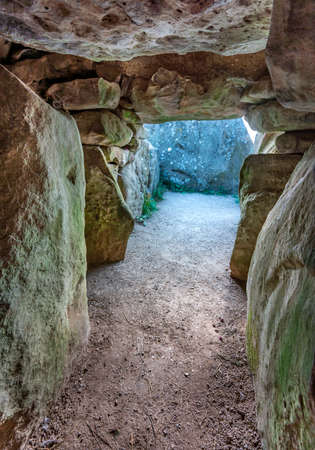 Looking out from within the barrow where the dead were buried,light creeps in as the sun rises, early on a clear August morning.の写真素材