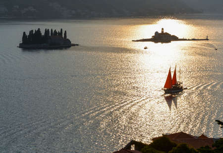 In the late summer sun, its sails glow in the backlight as it drifts by St Georges Island along the coast of this popular tourist destination.のeditorial素材