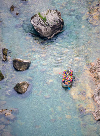 Durmitor,Montenegro-September 8th 2019: Beneath the high Tara Canyon Bridge,ten thrill seeking tourists in an inflatable raft, tackle the rapid waters of Tara River gorge,in late summer.のeditorial素材