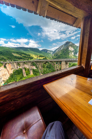 Seen through a glassless opening at a wood built cafe,overlooking the deep gorge and river below with beautiful mountain views.の写真素材