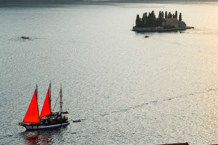 In the late summer sun, its sails glow in the backlight as it drifts by St Georges Island along the...