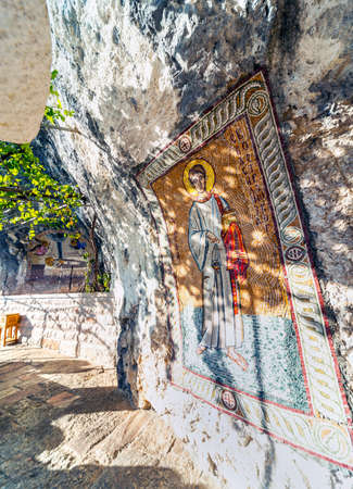 Christian orthodox artwork,colorfully covering the interior cave walls at the popular pilgrim and tourist site,the monastery is built high up,into the mountain side of Ostroska Greda.の写真素材