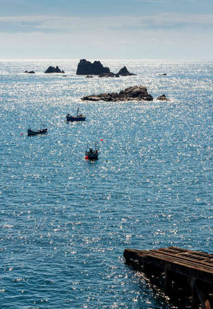 Sunlight glimmering from calm surface of the Atlantic,fine,clear,sunny summer weather,seabirds sunbathing on the distant rocks,the most southerly point of the British mainland.の写真素材