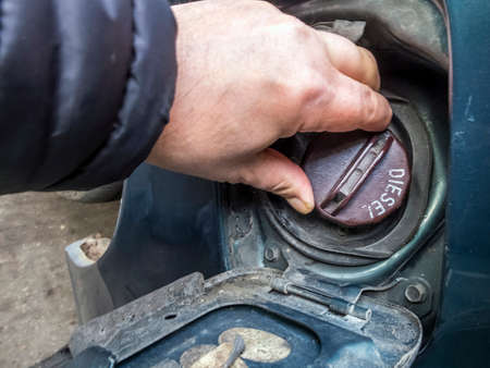 An English petrol filling station customer with an old diesel van,replaces the petrol cap, after...