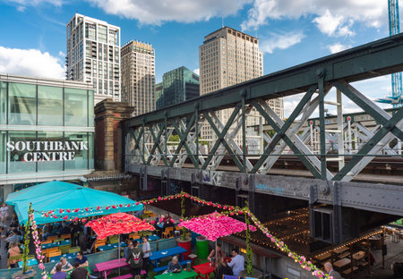 London,England,UK-July 21 2019: Customers enjoy socializing outdoors, in the warm summer weather, next to Hungerford Bridge and the river Thames.のeditorial素材