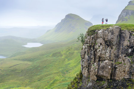 Beautiful,dramatic Scottish, Skye mountain scenery,jagged peaks,winding road and sheer cliffs, along the Quiraing hills walk,green course grass covered in mid summer,in the north east.のeditorial素材