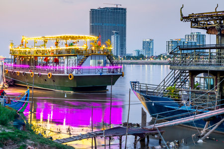 Colorfully lit at dusk,on the Riverside area of Phnom Penh,used as a nightspots for tourists,eating,drinking and dancing,whilst touring,brightly lit,along the adjoined Tonle Sap and Mekong rivers.の写真素材