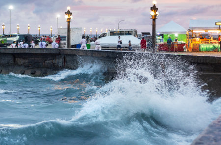 Choppy seas alongside Rizal Boulevard Extension,after sunset,lit by street lamps,with an evening breeze.Popular place for people to gather in the evening,practice Karate and stroll the sea wall.の写真素材