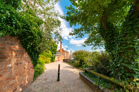A pretty,narrow pedestrian walkway,next to the main bus station and shopping center,leading past refurbished industrial buildings,down to Worcester High street.の写真素材