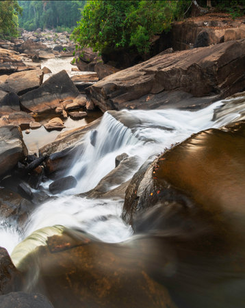 On the Pakse Loop route,long exposure water motion,over wonderful rock formations and large shining boulders,looking into the sunset along the Vang Ngao River,many water cascades.の写真素材