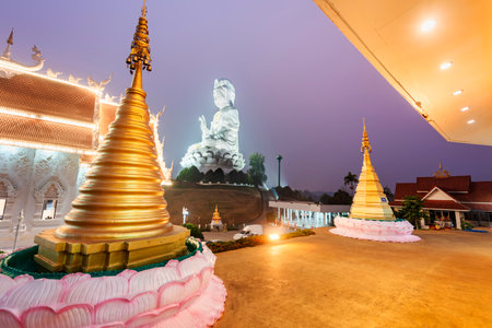 Illuminated at dusk,architecture is splendid with the mix of Chinese Guan Yin Statue, dragon stairs,...