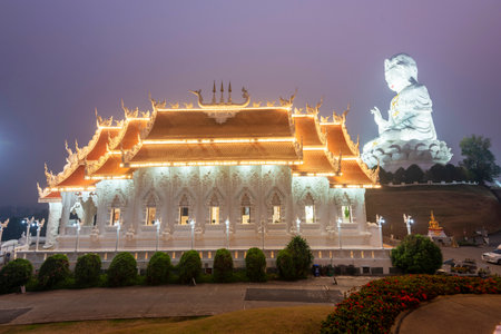 Illuminated at dusk,architecture is splendid with the mix of Chinese Guan Yin Statue, dragon stairs,...