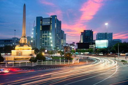 After sunset,during rush hour,the blurred movement of vehicles speed around the busy city center roundabout.の写真素材