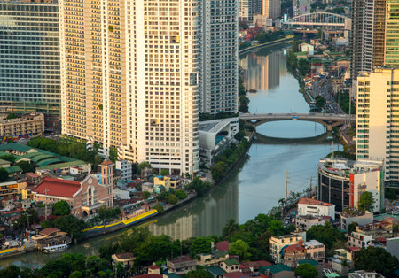 A traditional Philippines church sits below massive modern buildings, towering above, reflecting...