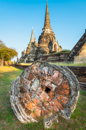 Part of the extensive temple grounds and important historic site,with many ancient Buddhist pagodas,with surrounding brickwork,stood amongst trees,bathed in the light of the setting sun.の写真素材